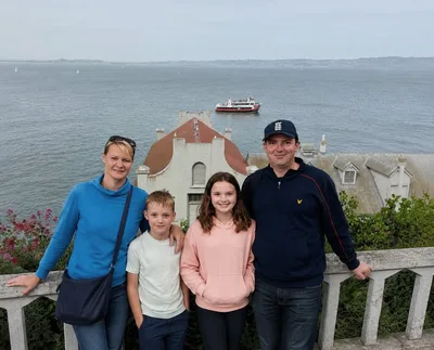 Family posing at Alcatraz Island with San Francisc...