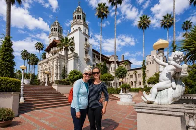 Two women smiling in front of Hearst Castle on the...