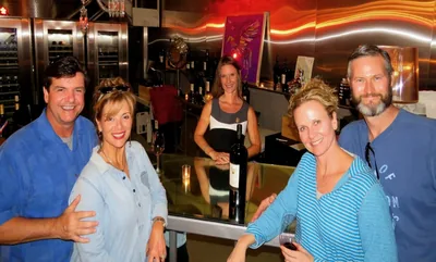 Friends posing at a castle-style winery entrance d...